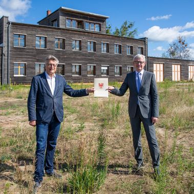 Dr. Fritz Brickwedde (links) nimmt den Fördermittelbescheid des Landes Brandenburg von Guido Beermann (rechts) entgegen. 