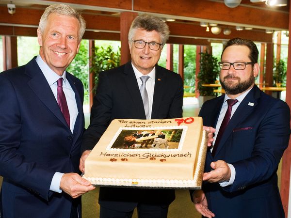 "Für einen starken Löwen": Dr.-Ing. E.h. Fritz Brickwedde (M.) - im Tierkreiszeichen Löwe geboren und engagiert für den Umbau von Löwengehege und -haus im Zoo Osnabrück - präsentiert eine Geburtstagstorte mit Bundespräsident a.D. Christian Wulff (l.) und DBU-Generalsekretär Alexander Bonde. Foto: DBU