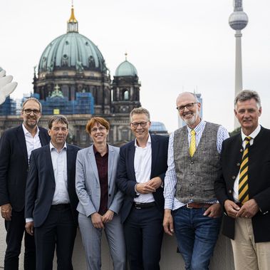 Gruppenfoto aller Podiumsgäste mit Moderator vor dem Berliner Dom.