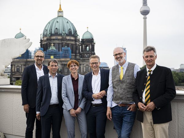 Gruppenfoto aller Podiumsgäste mit Moderator vor dem Berliner Dom.